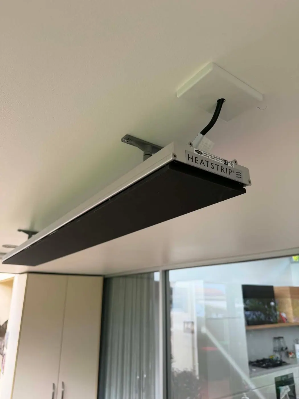 Heatstrip radiant heater on a ceiling drop bracket with the supply coming through a mounting plate above