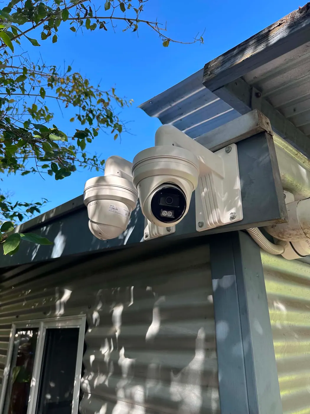 Two security cameras on a bracket under the eaves of a Golden Grove property
