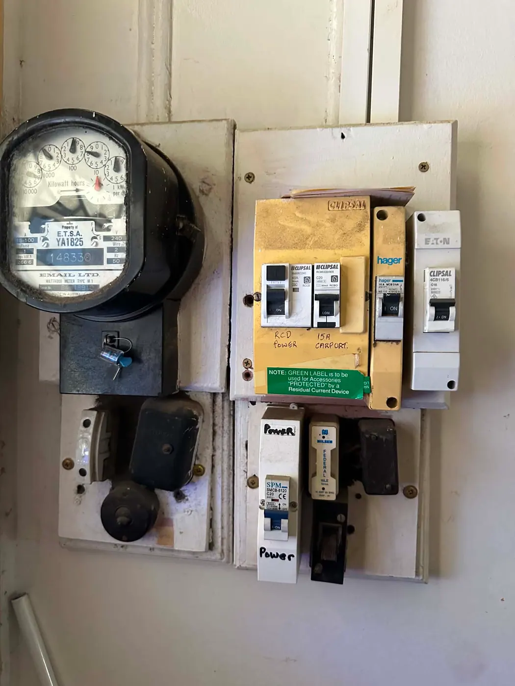Switchboard with hand-written labels and breakers from several different eras